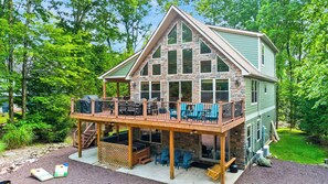 A two-story stone house with a deck and outdoor seating area. - Lake Harmony Chalet w/ Sauna, Hot tub,  Tensile Hammock, Game Room, Beach Passes (Lake Harmony)