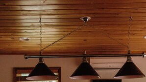A pool table with a red felt surface, overhead lighting fixtures, and a framed picture on the wall. - Lake Harmony Chalet w/ Sauna, Hot tub,  Tensile Hammock, Game Room, Beach Passes (Lake Harmony)