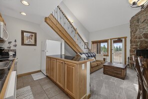 A kitchen with wooden cabinets, a black countertop, and a stainless steel sink. - Cozy Mountain Condo with Resort Amenities | Pet-Friendly (Granby)