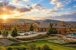 Eine Lodge mit mehreren Gebäuden, einem Swimmingpool und einer Bergkulisse.