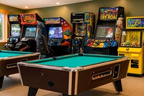Ein Raum mit mehreren Spielautomaten und Billardtischen.