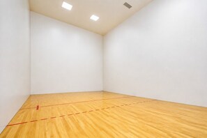 Una habitación con paredes blancas y suelo de madera marcado con líneas rojas.