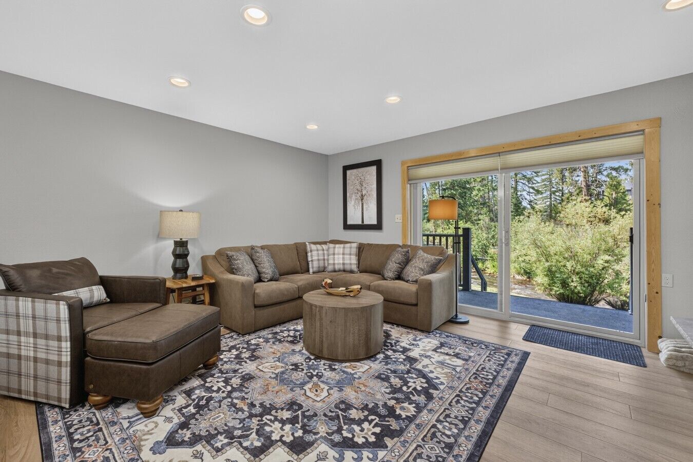 A living room with a sectional sofa, a loveseat, a coffee table, and a patterned rug.