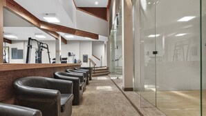 A reception area with a counter, leather seating, a staircase, and a glass wall. - Meadow Ridge Retreat | Pool, Hot Tub & Near Winter Park (Fraser)