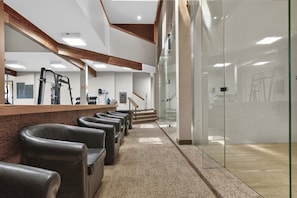 A reception area with a counter, leather seating, a staircase, and a glass wall. - Meadow Ridge Retreat | Pool, Hot Tub & Near Winter Park (Fraser)