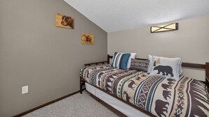 A bedroom with a bed, two wall-mounted paintings, and a ceiling light fixture. - Meadow Ridge Retreat | Pool, Hot Tub & Near Winter Park (Fraser)
