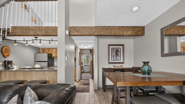A modern interior with a kitchen, dining area, and living space. - Meadow Ridge Retreat | Pool, Hot Tub & Near Winter Park (Fraser)
