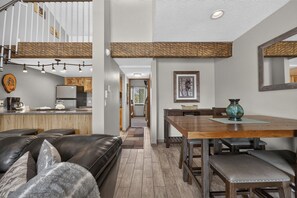 A modern interior with a kitchen, dining area, and living space. - Meadow Ridge Retreat | Pool, Hot Tub & Near Winter Park (Fraser)