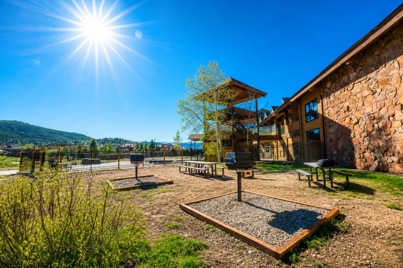 A building with a stone facade, outdoor seating, and a view of the surrounding landscape.