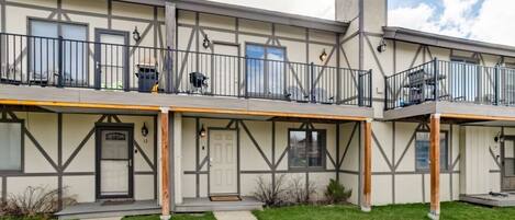 A two-story building with a balcony on the upper floor, a front door, and a small porch area.