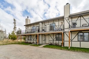 Ein zweistöckiges Gebäude mit Balkon und Schornstein.