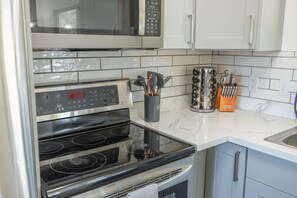 A kitchen with a microwave, oven, and various utensils. - House near Snowbird, Alta - Hot Tub, Games (Sandy)
