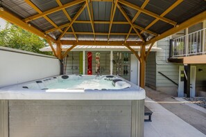 A hot tub under a covered patio with a wooden roof structure. - House near Snowbird, Alta - Hot Tub, Games (Sandy)
