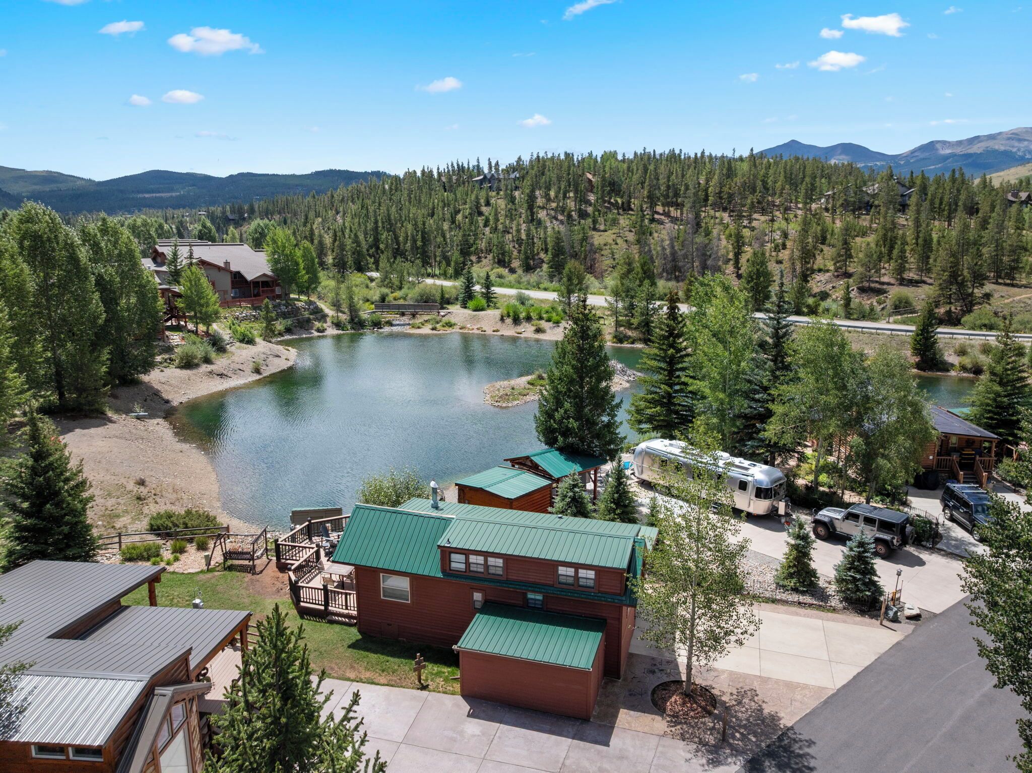 A lakeside lodge with cabins, a boat dock, and a forested backdrop.