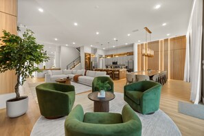 A modern living room with green armchairs, a coffee table, and a dining area with a wooden table and chairs. - 15 BD/ 16.5 BA/ Sonoma Resort (4231 SB) (Kissimmee)