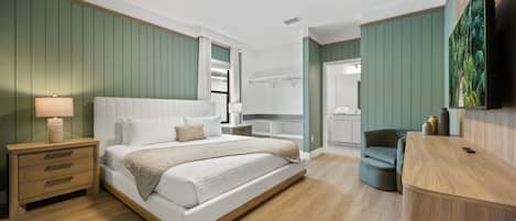 Un dormitorio moderno con una cama, mesita de noche y televisor montado en la pared.