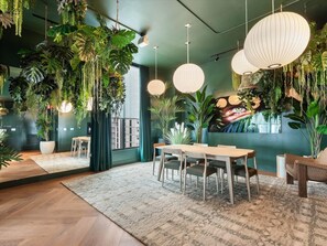 A room with a dining table, chairs, hanging plants, and pendant lights. - 501 First #912B Stylish Highrise Studio (Miami)