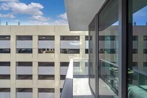 A multi-story building with a glass balcony overlooking a parking garage. - 501 First #912B Stylish Highrise Studio (Miami)