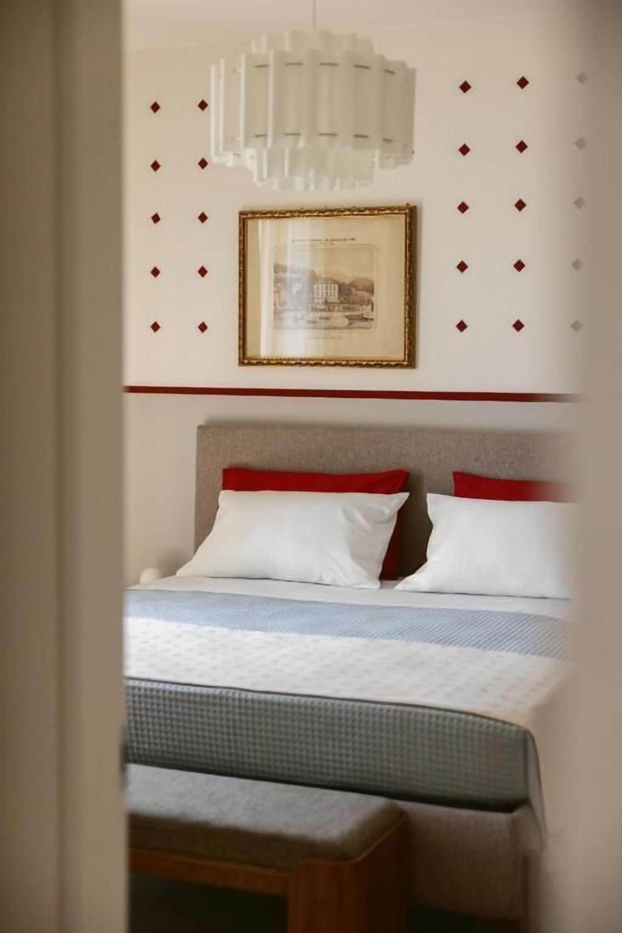 Un letto con una testiera, cuscini e un comodino.