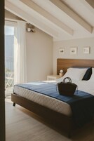 Una camera da letto con un letto, un comodino e vista sull'esterno.