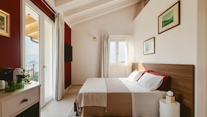 Habitación de hotel con cama, escritorio, silla, ventana y vistas al exterior.