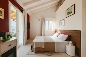 Habitación de hotel con cama, escritorio, silla, ventana y vistas al exterior.