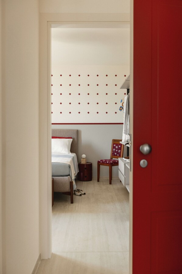 A bedroom with a bed, a chair, a nightstand, and a dresser. - Hortus Bellagio (Bellagio)