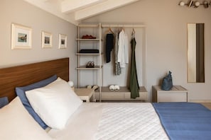 A bedroom with a bed, a bedside table, a wardrobe, and a mirror.