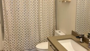Un baño con cortina de ducha, inodoro, lavabo y espejo.