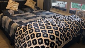 Un dormitorio con cama, ventana y vistas al exterior.
