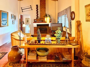 A cozy living room with a fireplace, a Christmas tree, and a variety of decorative items. - Mountain Retreat among Coffee fields & Nature (Los Naranjos)