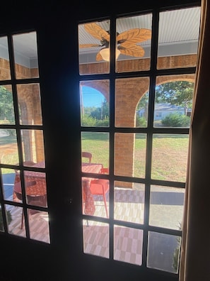 A view through a window with a brick wall and a red chair outside. - Charming Historic Tudor (Palestine)