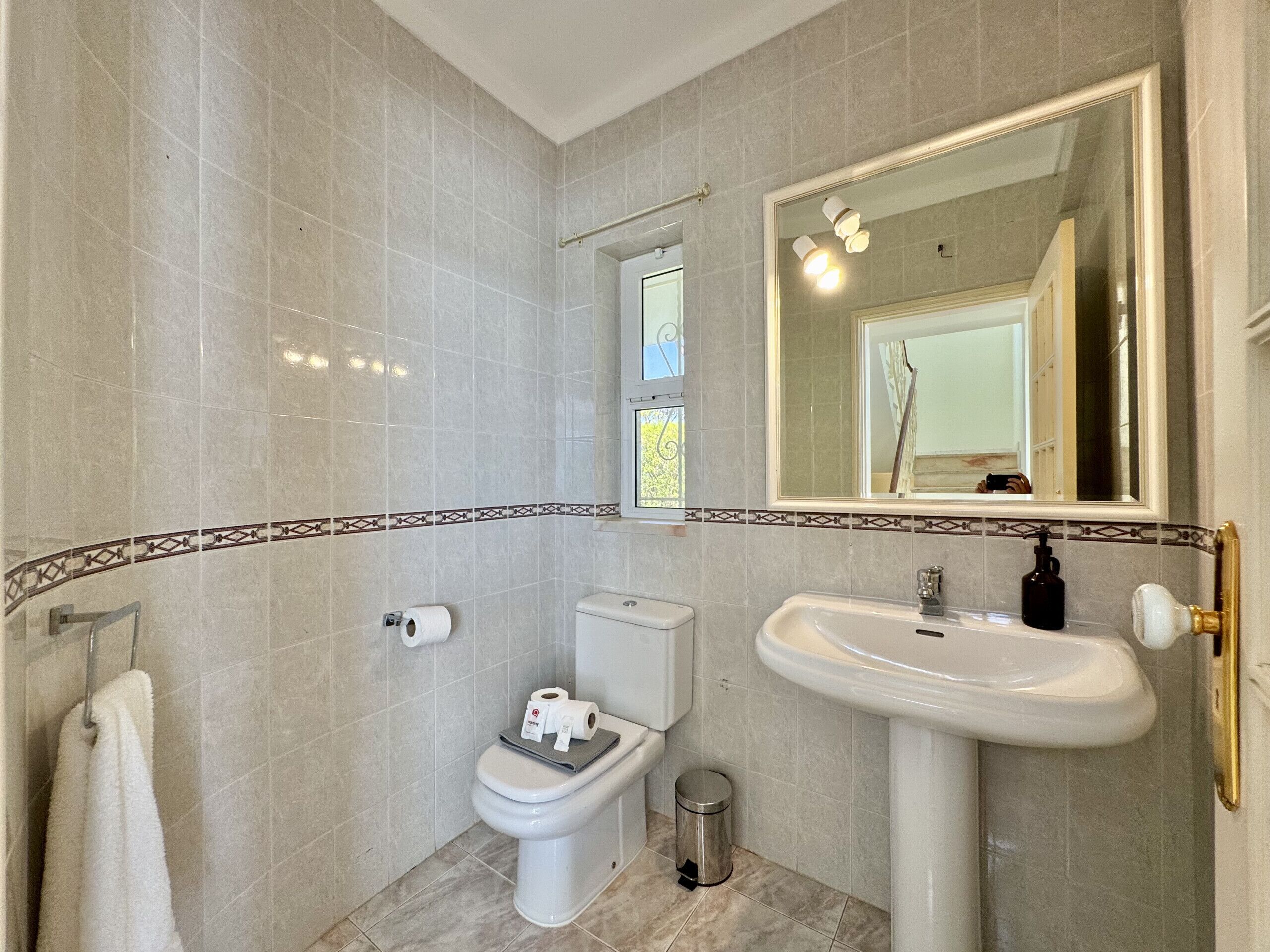 Un baño con inodoro, lavamanos y espejo.