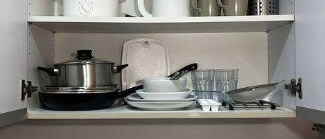 A kitchen with a built-in stove, a sink, and a countertop with various kitchenware.