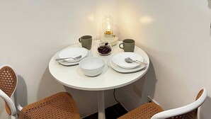 Uma pequena sala de jantar com uma mesa redonda, quatro cadeiras e um abajur.