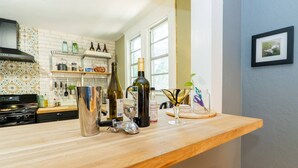 A kitchen with a wooden countertop, a stove, and various kitchen items. - Casa Grande | Historic 2BR Bungalow with Private Porch Near Ybor, Armature Works & Downtown Tampa (Tampa)