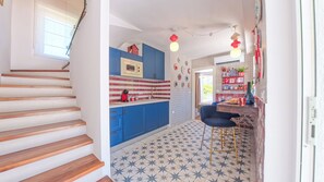 Eine moderne Küche mit blauen Schränken, einer roten und weißen Spritzschutzwand sowie einem fußbodenhohen Sternenmuster.