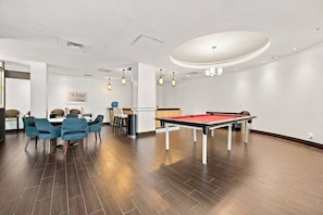 A billiards table in a room with a dining area and a reception desk. - Spacious & Modern apt for a family beach vacation (Hollywood)