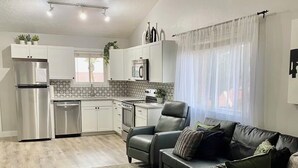 Eine moderne Küche mit weißen Schränken, Edelstahlgeräten und einem Deckenventilator.