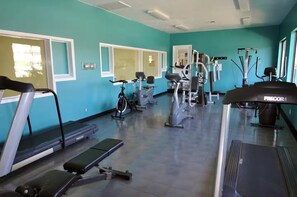 A gym with various exercise equipment including treadmills, stationary bikes, and elliptical machines. - Sunny Getaway at Sports Village (St. George)