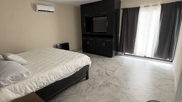 A modern bedroom with a bed, a TV, and a wardrobe.