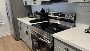 Una cocina moderna con electrodomésticos de acero inoxidable, microondas, horno y refrigerador.
