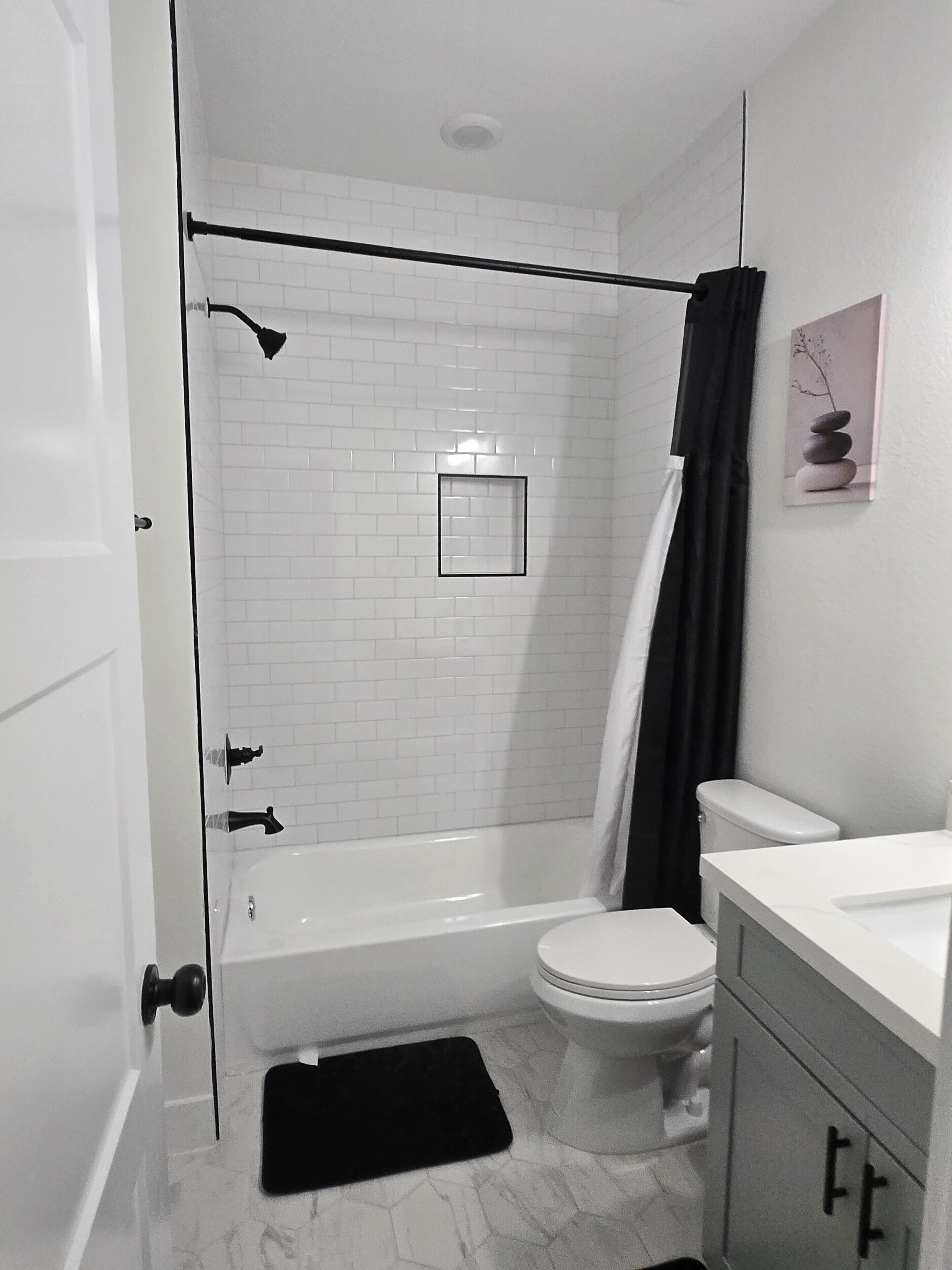 Ein Badezimmer mit Badewanne, Toilette und Duschvorhang.