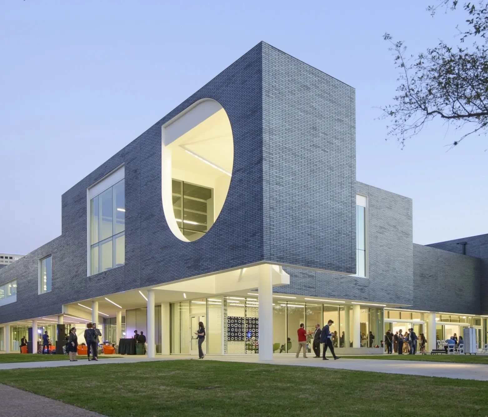 Un edificio moderno con una amplia fachada de vidrio y un corte geométrico distintivo.