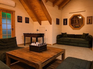 A cozy room with a wooden table, a sofa, and a chessboard.