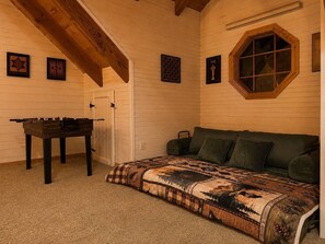 A cozy room with a bed, a futsal table, and a window.