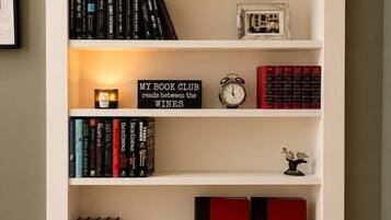 Une bibliothèque remplie de livres, une horloge et des objets décoratifs.