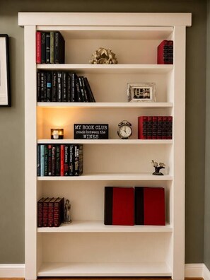Una prestatgeria amb llibres, un rellotge i elements decoratius.