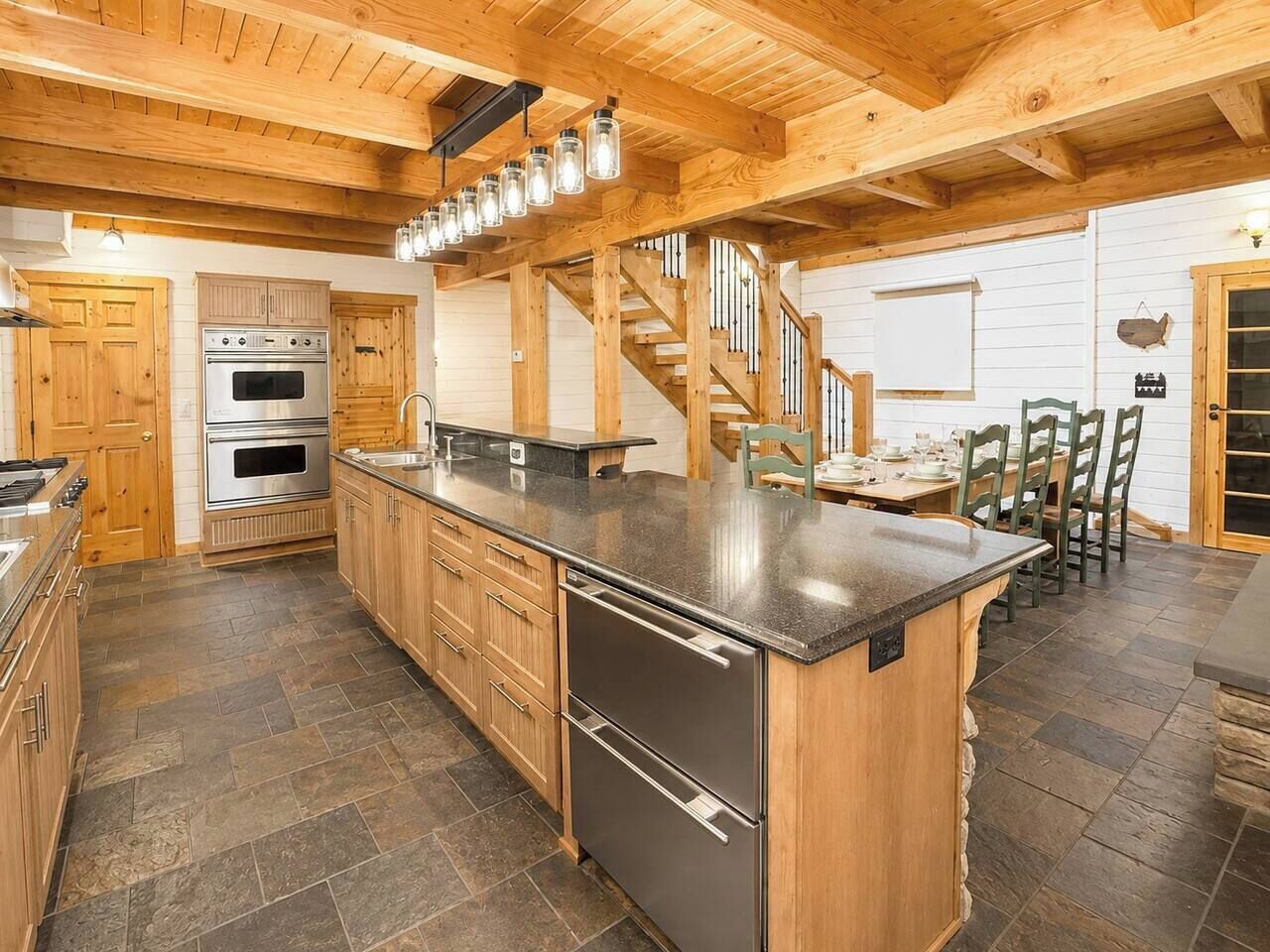 Une cuisine avec des meubles en bois, un îlot central, une cuisinière et un évier.