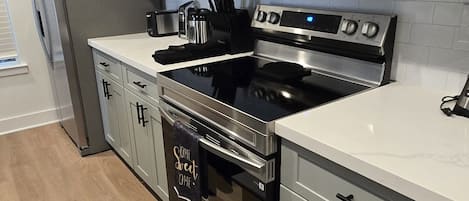 A modern kitchen with stainless steel appliances, a microwave, oven, and a refrigerator.